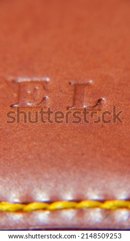 Letters E and L stamped in brown leather cover