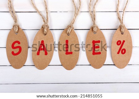 Sale tags on white wooden background