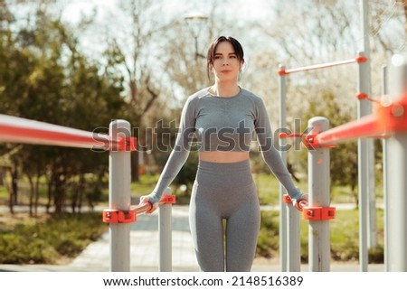 A young beautiful woman in a sports uniform trains outside