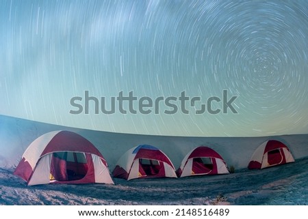 night tent camp with star trail on sandy beach of baja california sur