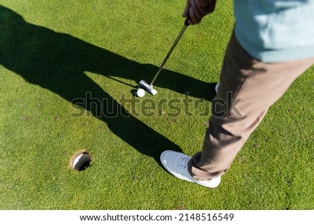 top view of man in white sneakers playing golf on lawn, banner