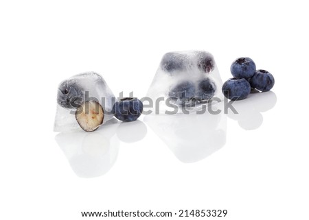 Blueberries frozen in ice cubes isolated on white background. Fresh healthy summer fruit eating. 