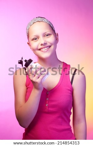 Beautiful happy teen girl holds bottle with water and smiling