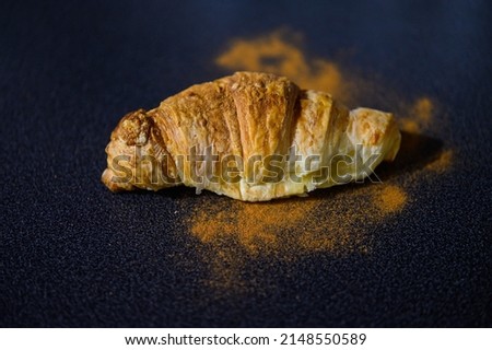 One fresh croissant on a dark background