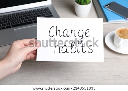 Woman holding paper note with phrase Break Bad Habits at table, closeup