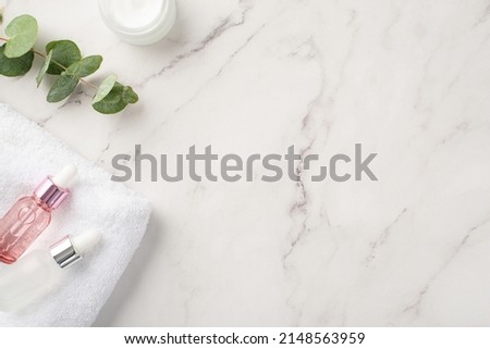 Skincare concept. Top view photo of cream jar glass transparent dropper bottles eucalyptus and white towel on white marble background with copyspace Royalty-Free Stock Photo #2148563959