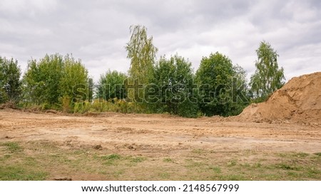 Road construction. Sand mounds and leveled land. Driveways. Creation of infrastructure. Nature landscape. Summer. Rural country road. Close-up. Copy space. Nobody. No people. Earthwork. Sand quarry. Royalty-Free Stock Photo #2148567999
