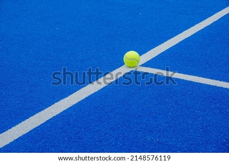 a ball on the lines of a blue paddle tennis court Royalty-Free Stock Photo #2148576119