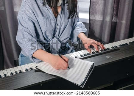 Music.girl plays  piano. Music background, creates music, a soundtrack. Business hobbies, relaxation and psychology. Education and remote work music making.