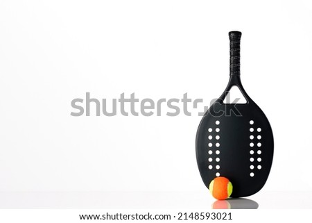 Black professional beach tennis racket and ball on white background. Horizontal sport theme poster, greeting cards, headers, website and app Royalty-Free Stock Photo #2148593021