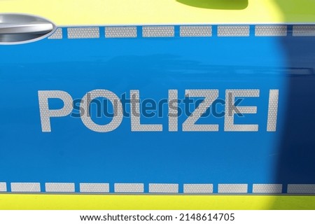 Police (German: Polizei). Sign on a police car. The right side is in shadow. Selected focus.