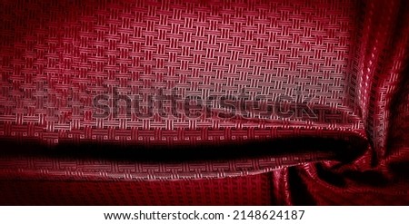 Red silk fabric with a fine checkered pattern. Background texture, pattern.
