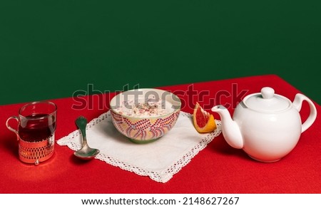 Served table. Food pop art photography. Glass of milk, cake and flower on blue and turquoise color tablecloth over red background. Retro 80s, 70s style. Complementary colors, Copy space for ad, text