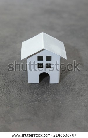Simply design with miniature white toy model house on concrete stone grey background. Mortgage property insurance dream home concept. Copy space