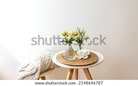 Home composition with rose flowers in a vase in the interior of a white room, copy space.