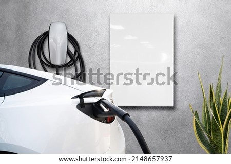 Home garage charging electric vehicle with cable Tesla Royalty-Free Stock Photo #2148657937