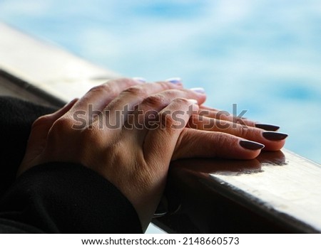 Female Hands on a Wooden Railing