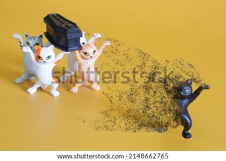 Funeral procession of toy dancing kittens. Leaving the body of the soul. Superstition. The concept of the exit of the soul from the body after death and rebirth. Yellow background. Close-up