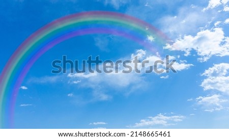 Bright blue sky with rainbow and sunshine