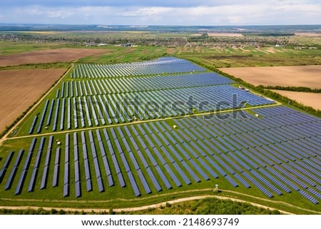 Aerial view of big sustainable electric power plant with many rows of solar photovoltaic panels for producing clean ecological electrical energy. Renewable electricity with zero emission concept.