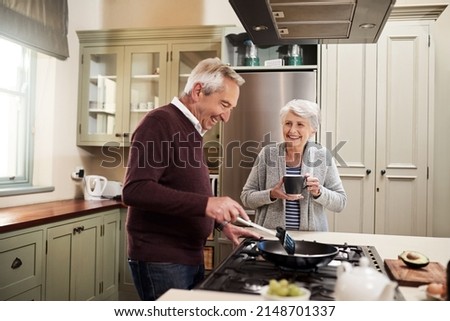 Getting ready to cook her favorite meal. Shot of an affectionate senior couple cooking together in their kitchen at home.