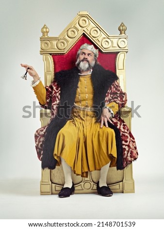 Servants Come hither. Studio shot of a richly garbed king sitting on a throne. Royalty-Free Stock Photo #2148701539