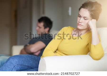 Time for the silent treatment. Cropped shot of an unhappy young couple sitting on the couch at home after a fight. Royalty-Free Stock Photo #2148702727