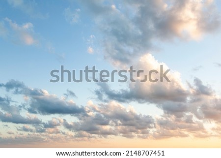 Sunset on blue sky. Blue sky with some clouds. blue sky clouds, summer skies, cloudy blue sky background. Aerial sunset view.  Evening skies with dramatic clouds. View over the clouds. Royalty-Free Stock Photo #2148707451