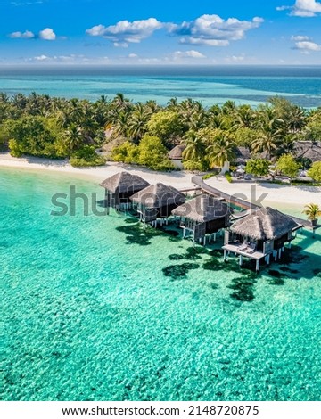 Perfect aerial landscape, luxury tropical resort with water villas. Beautiful island beach, palm trees, sunny sky. Amazing bird eyes view in Maldives, paradise coast. Exotic tourism, relax nature sea Royalty-Free Stock Photo #2148720875