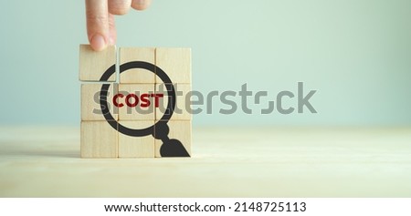 Cost management concept. Lean, control, reduction, optimization costs. Efficiency project management for cost leadership in market. Placing wooden cubes with cost, magnifier glass on smart background. Royalty-Free Stock Photo #2148725113