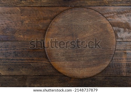 Cutting kitchen board on brown wooden table. Space for text. Top view.