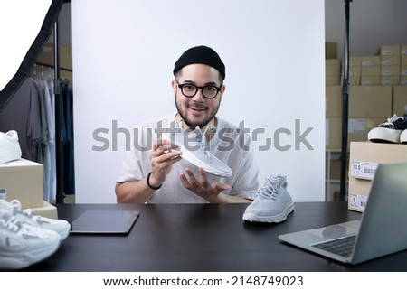 Young attractive Asian man blogger or vlogger looking at camera reviewing product. Modern businessman using social media for marketing. Business online influencer on social media concept. Royalty-Free Stock Photo #2148749023