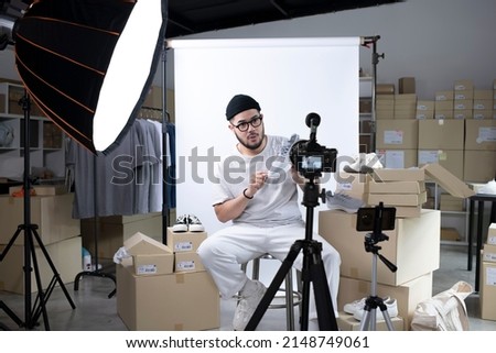 Young attractive Asian man blogger or vlogger looking at camera reviewing product. Modern businessman using social media for marketing. Business online influencer on social media concept. Royalty-Free Stock Photo #2148749061
