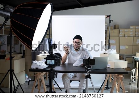 Young attractive Asian man blogger or vlogger looking at camera reviewing product. Modern businessman using social media for marketing. Business online influencer on social media concept. Royalty-Free Stock Photo #2148750127