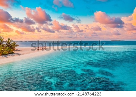 Aerial view of amazing beach, couple umbrellas, chairs beds close to sea lagoon. Fantastic sky clouds summer beach landscape. Idyllic nature for inspire tourism vacation, romantic holiday in Maldives Royalty-Free Stock Photo #2148764223