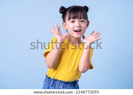 Image of Asian child posing on blue background Royalty-Free Stock Photo #2148772095