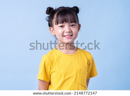 Image of Asian child posing on blue background Royalty-Free Stock Photo #2148772147