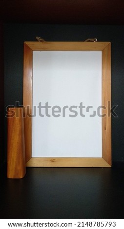 Mockup wooden frame on black wall with wooden flower pot. Clean, modern, minimal frames.