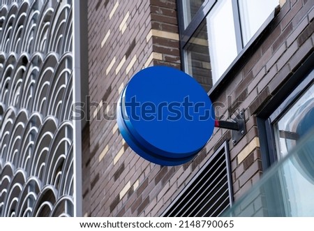 Blank blue round store signboard mockup. Empty circular illuminated shop lightbox template mounted on wall. Mock up of blank signboard. Place for text, outdoor advertising, banner