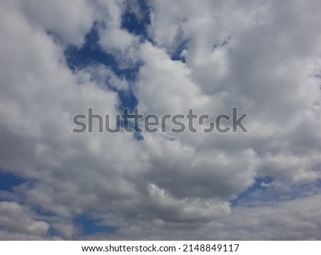 A collection of unified clouds adorn the blue sky