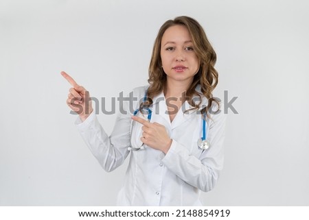 Girl nurse in a medical gown with a stethoscope around her neck shows a sign with her hands. Isolated on white background.