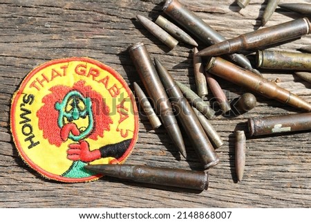 HOW'S THAT GRAB YA Patch US SPECIAL FORCES - Capture VC  Vietnam War, Military Patch US Army Military Ammunition bulet on wood background - Image