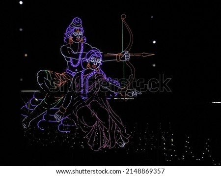 Hindu God Sri Rama and his wife Sita. Ram shooting an arrow from his bow. Image made of tiny electric bulbs.                                Royalty-Free Stock Photo #2148869357
