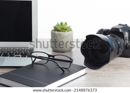 professional camera on work table with laptop