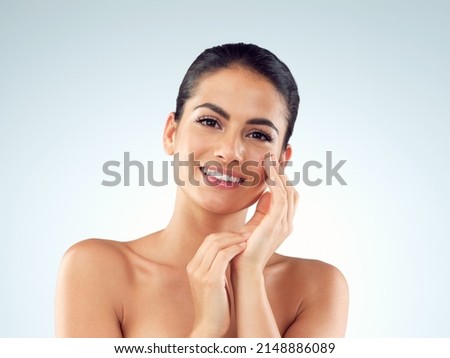 Shes been gifted with a gorgeous glowy complexion. Studio shot of an beautiful young woman feeling her skin against a gray background. Royalty-Free Stock Photo #2148886089