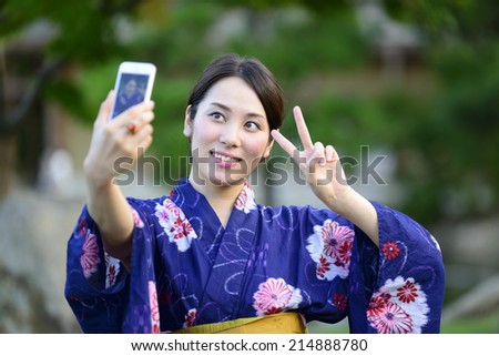 Japanese girl taking a self portrait with smart phone 