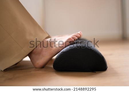 Worker Using Footrest To Reduce Back Strain And Feet Fatigue Royalty-Free Stock Photo #2148892295