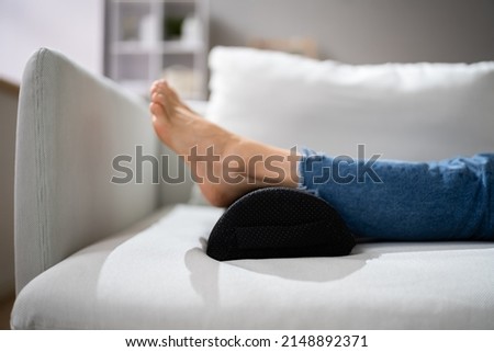 Woman Using Footrest To Reduce Back Strain And Feet Fatigue Royalty-Free Stock Photo #2148892371