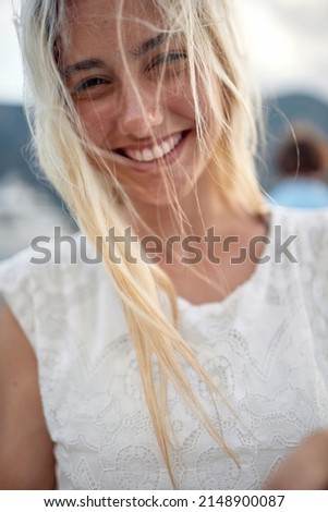 Close-up of a young girl posing for a photo on a beautiful day on the seaside. Holiday, sea