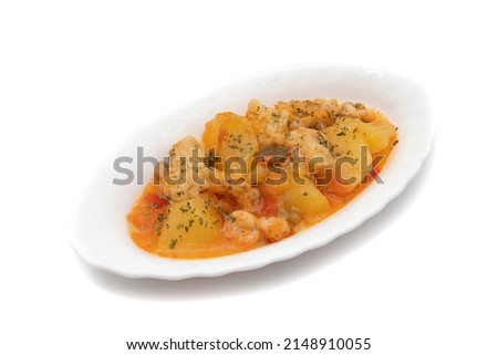 Potato stew with cod, shrimp and parsley on top, served on a white plate. Isolated on white background, Selective focus. Spanish food.